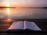 Open Bible on Dock at Sunrise